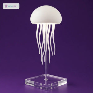 Lámpara de medusas LumaJelly™ con base de pedestal acrílica transparente sobre fondo púrpura. Iluminación LED decorativa de alta calidad.